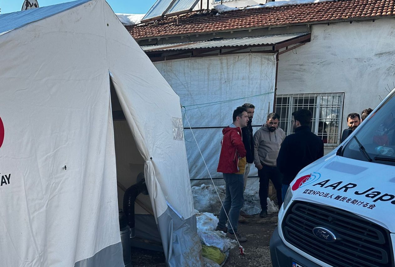 テントで生活する被災者に支援物資を届けるAAR職員＝アドゥヤマン県